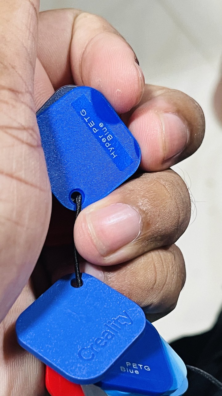 Batch of blue PETG tags held in a hand