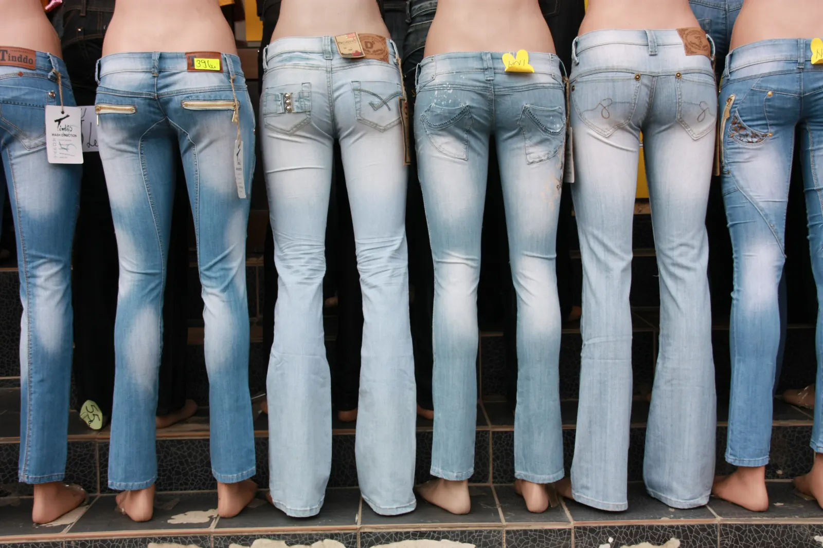 A row of jeans in visibly different shades of blue