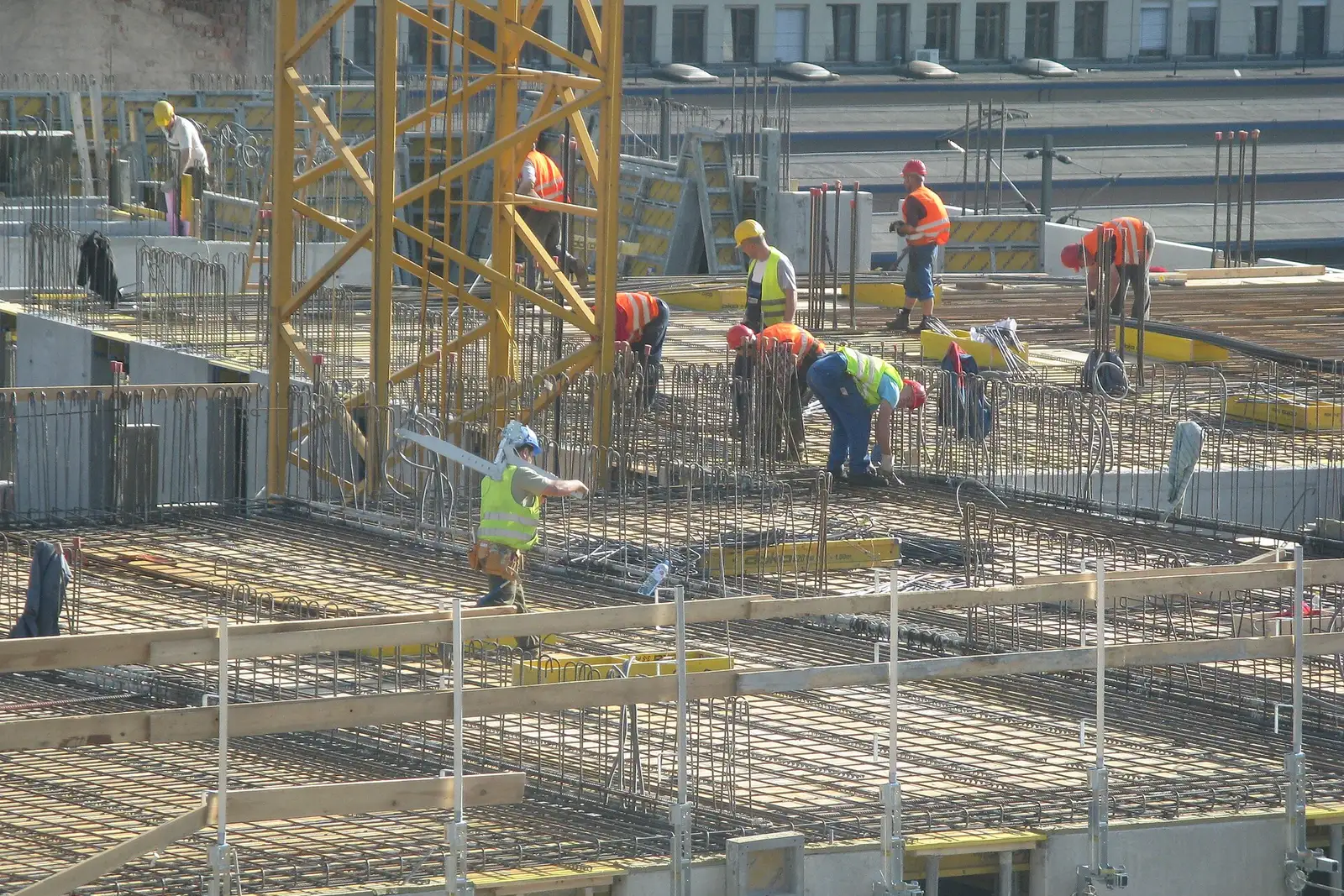 Overhead view of construction workers in hard hats and high visibility vests on a building site